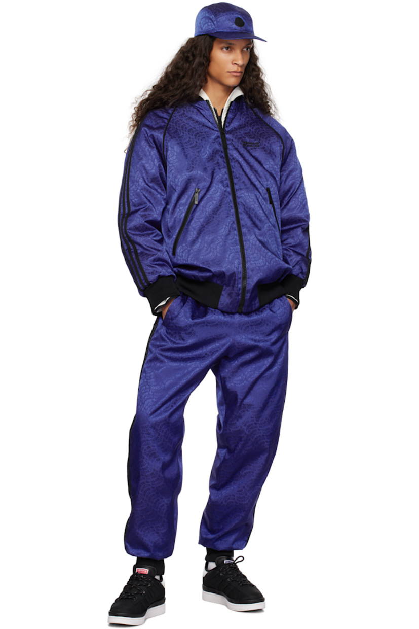 Down-filled nylon twill trousers. Logo pattern throughout. 

· Concealed drawstring at elasticized waistband 
· Two-pocket styling 
· Rib knit cuffs 
· Jersey stripes at outseams 
· Rubberized logo patch at outseam 
· Rubberized logo appliqué at back 
· Full quilted satin lining 

Part of the Moncler Genius x adidas Originals collaboration.

Supplier color: Blue 

Fill: 90% goose down, 10% feathers.