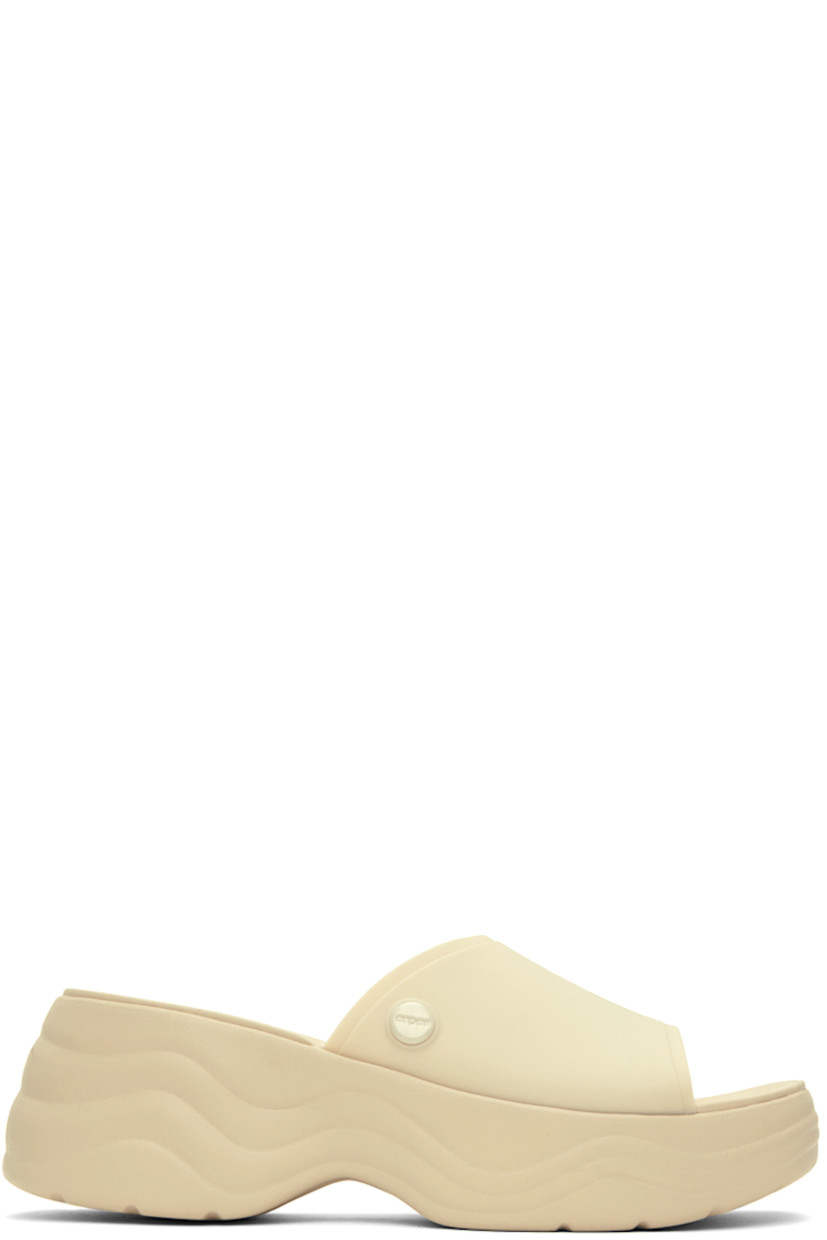 TPU slip-on sandals in off-white.

· Open square toe
· Logo hardware at outer side
· Logo embossed at molded footbed
· Croslite™  foam rubber platform midsole
· Treaded rubber outsole
· Platform: H1.5 in
· Heel: H2.5 in

Supplier color: Bone