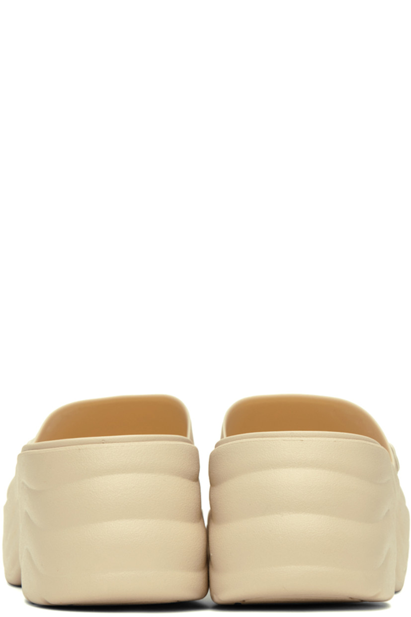 TPU slip-on sandals in off-white.

· Open square toe
· Logo hardware at outer side
· Logo embossed at molded footbed
· Croslite™  foam rubber platform midsole
· Treaded rubber outsole
· Platform: H1.5 in
· Heel: H2.5 in

Supplier color: Bone