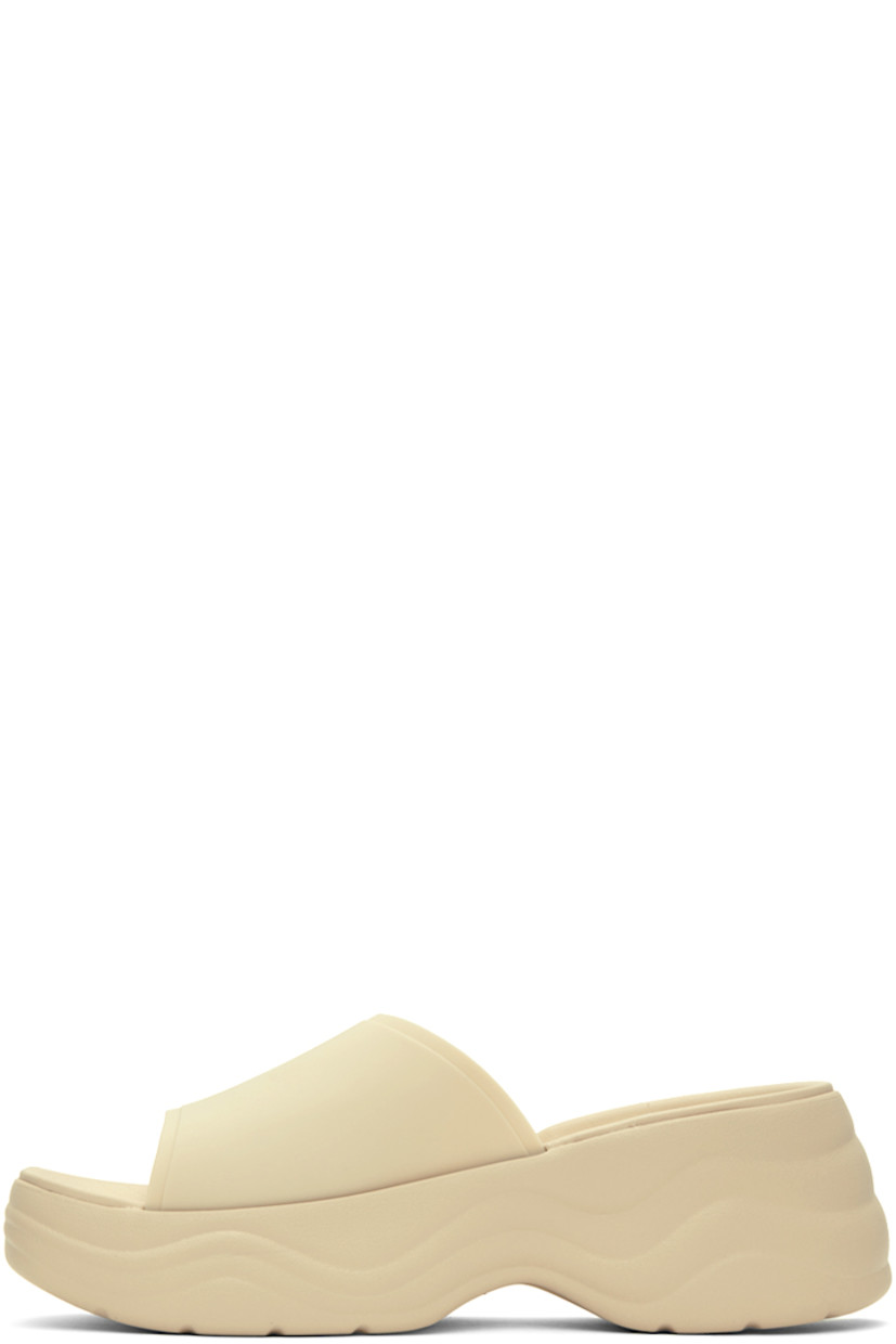 TPU slip-on sandals in off-white.

· Open square toe
· Logo hardware at outer side
· Logo embossed at molded footbed
· Croslite™  foam rubber platform midsole
· Treaded rubber outsole
· Platform: H1.5 in
· Heel: H2.5 in

Supplier color: Bone