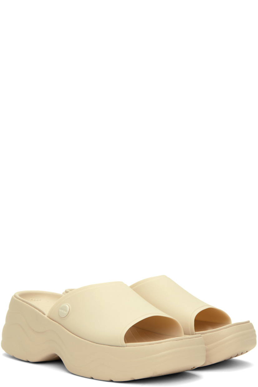 TPU slip-on sandals in off-white.

· Open square toe
· Logo hardware at outer side
· Logo embossed at molded footbed
· Croslite™  foam rubber platform midsole
· Treaded rubber outsole
· Platform: H1.5 in
· Heel: H2.5 in

Supplier color: Bone