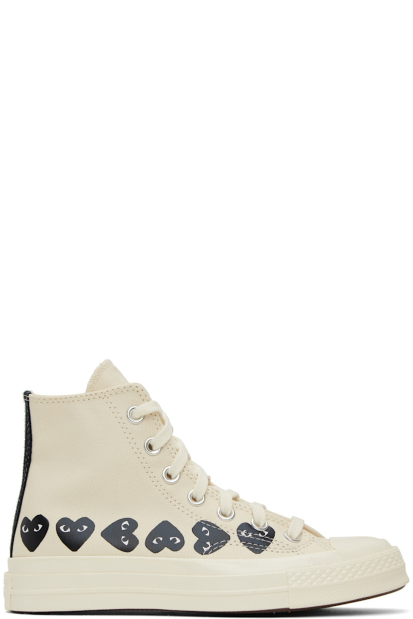 High-top canvas sneakers in off-white. Logo graphics printed at outer side.

· Rubber cap toe
· Lace-up closure
· Metal eyelets at inner side
· Logo embossed at heel
· Bonded logo at inner side
· Cushioned Ortholite® footbed
· Treaded vulcanized rubber sole

Part of the Comme des Garçons PLAY x Converse collaboration.

Supplier color: Beige