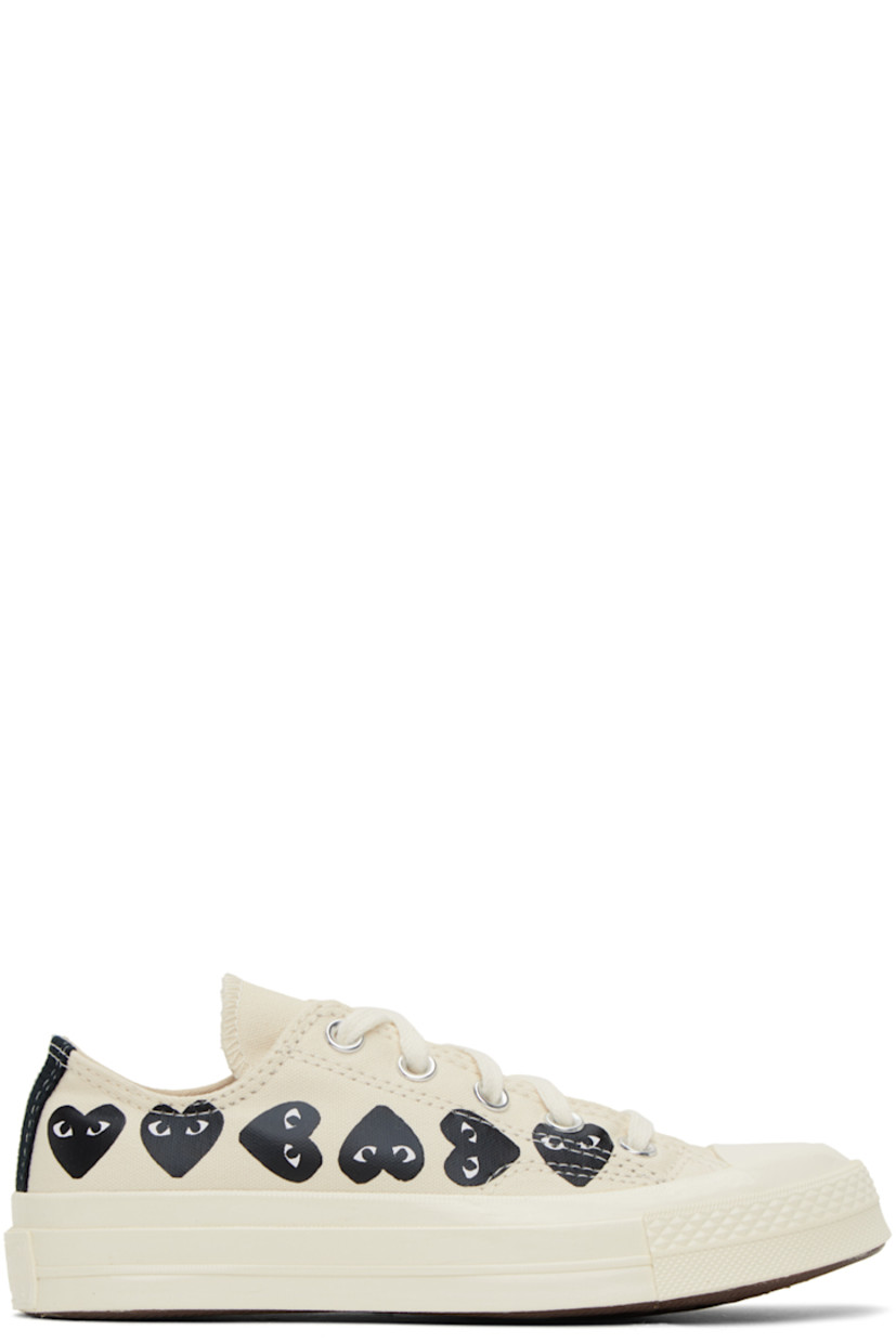 Low-top canvas sneakers in beige. 

· Rubber cap toe
· Lace-up closure
· Logo graphics printed at sides
· Metal eyelets at inner side
· Logo embossed at heel
· Cushioned Ortholite® footbed
· Treaded vulcanized rubber sole

Part of the Comme des Garçons PLAY x Converse collaboration.

Supplier color: Beige