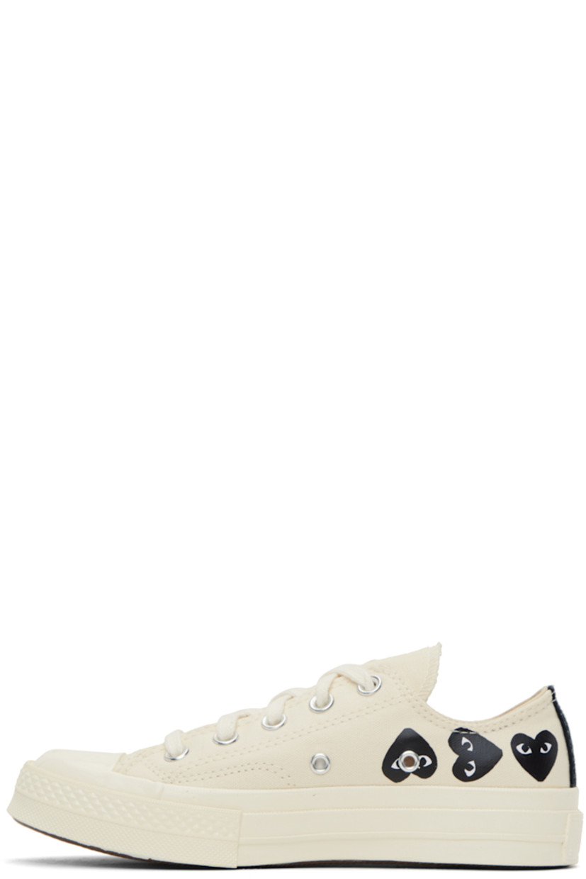 Low-top canvas sneakers in beige. 

· Rubber cap toe
· Lace-up closure
· Logo graphics printed at sides
· Metal eyelets at inner side
· Logo embossed at heel
· Cushioned Ortholite® footbed
· Treaded vulcanized rubber sole

Part of the Comme des Garçons PLAY x Converse collaboration.

Supplier color: Beige