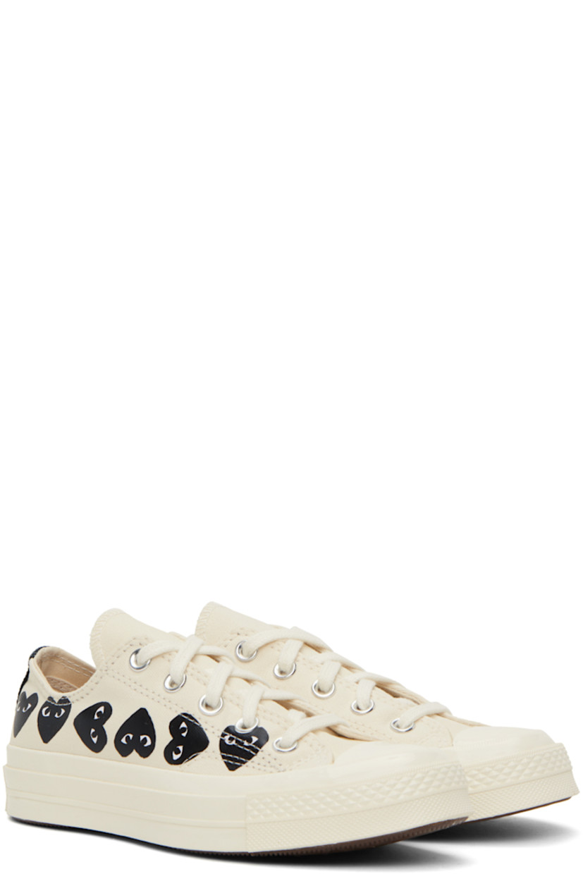 Low-top canvas sneakers in beige. 

· Rubber cap toe
· Lace-up closure
· Logo graphics printed at sides
· Metal eyelets at inner side
· Logo embossed at heel
· Cushioned Ortholite® footbed
· Treaded vulcanized rubber sole

Part of the Comme des Garçons PLAY x Converse collaboration.

Supplier color: Beige