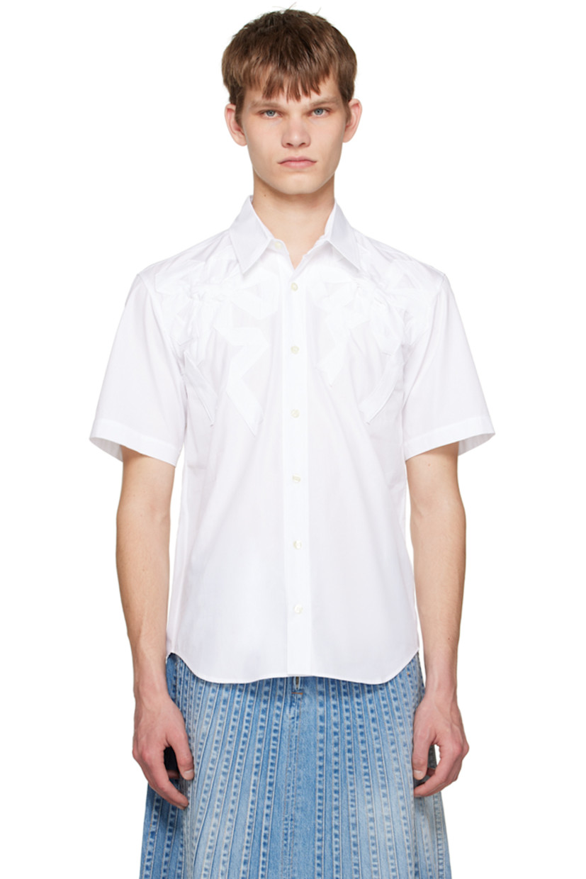 Cotton poplin shirt. 

· Spread collar 
· Button closure 
· Bow appliqués at front 
· Shirttail hem 
· Box pleat at back yoke 

Supplier color: White