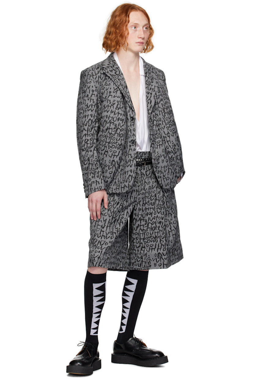 Wool- and polyester-blend houndstooth blazer. Jacquard woven check pattern and printed text throughout.

· Notched lapel
· Two-button closure
· Sculptural padded inserts at front
· Three-button surgeon's cuffs
· Central vent at back hem
· Welt pockets at interior
· Full satin lining

Supplier color: Black/Natural/Black