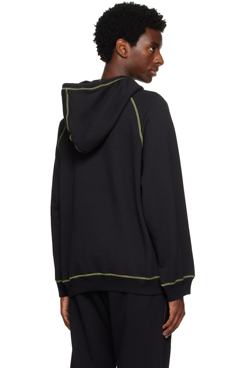 Cotton-blend fleece hoodie. 

· Hand-woven awassi wool Bedouin tassels at hood
· Hand-stitched tatreez embroidery at chest
· Kangaroo pocket
· Rib knit hem and cuffs
· Raglan sleeves
· Contrast stitching in green

Supplier color: Black