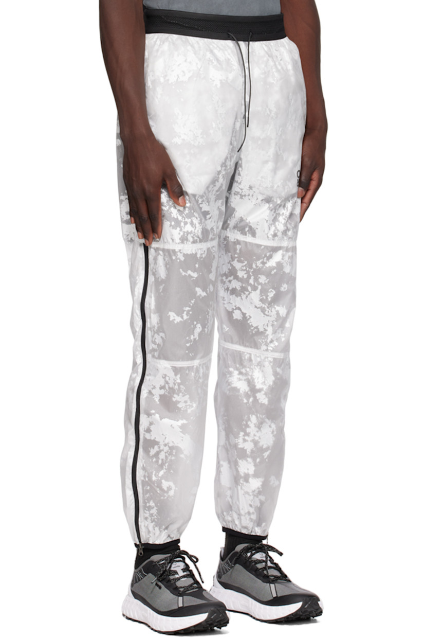 Nylon taffeta track pants. Graphic pattern throughout.

· Paneled construction
· Drawstring at elasticized waistband
· Two-pocket styling
· Logo print at front
· Elasticized cuffs
· Zip vent at outseams 
· Logo flag at back waistband
· Partial mesh lining

Supplier color: White foil