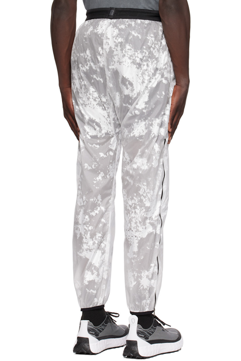 Nylon taffeta track pants. Graphic pattern throughout.

· Paneled construction
· Drawstring at elasticized waistband
· Two-pocket styling
· Logo print at front
· Elasticized cuffs
· Zip vent at outseams 
· Logo flag at back waistband
· Partial mesh lining

Supplier color: White foil