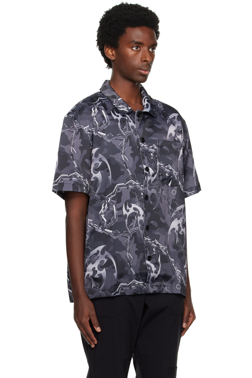 Crinkled polyester satin shirt. Graphic pattern printed throughout. 

· Spread collar
· Button closure
· Patch pocket at chest
· Graphic hardware at vented side seams

Supplier color: Camo