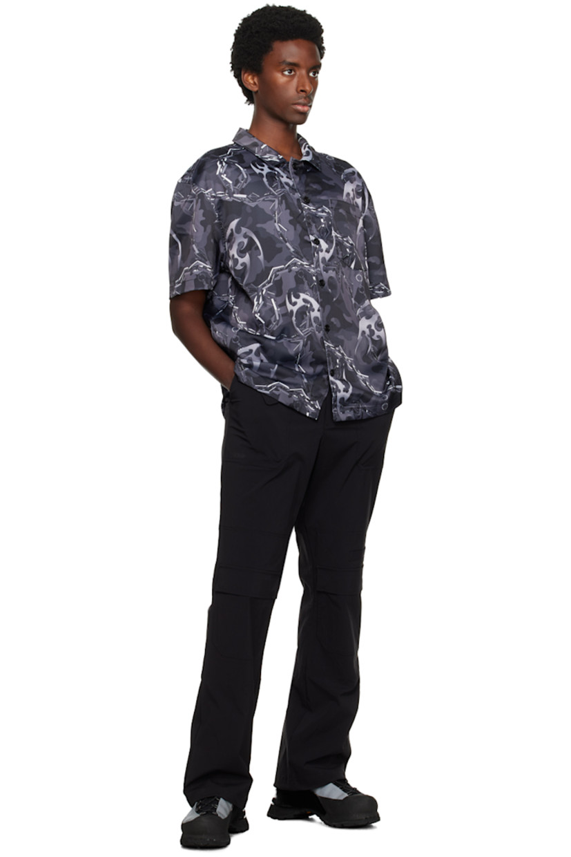 Crinkled polyester satin shirt. Graphic pattern printed throughout. 

· Spread collar
· Button closure
· Patch pocket at chest
· Graphic hardware at vented side seams

Supplier color: Camo