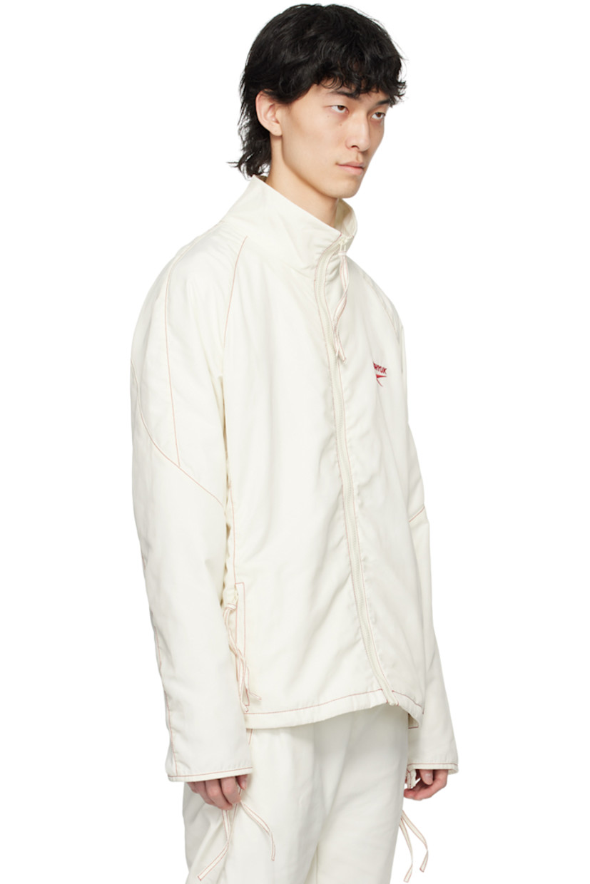 Polyester taffeta track jacket. 

· Paneled construction 
· Stand collar
· Zip closure
· Logo embroidered at chest and back collar
· Zip pockets
· Raglan sleeves
· Zip vent at cuffs and back hem
· Contrast stitching in red
· Full mesh lining 

Part of the Kanghyuk x Reebok collaboration. 

Supplier color: White/Red