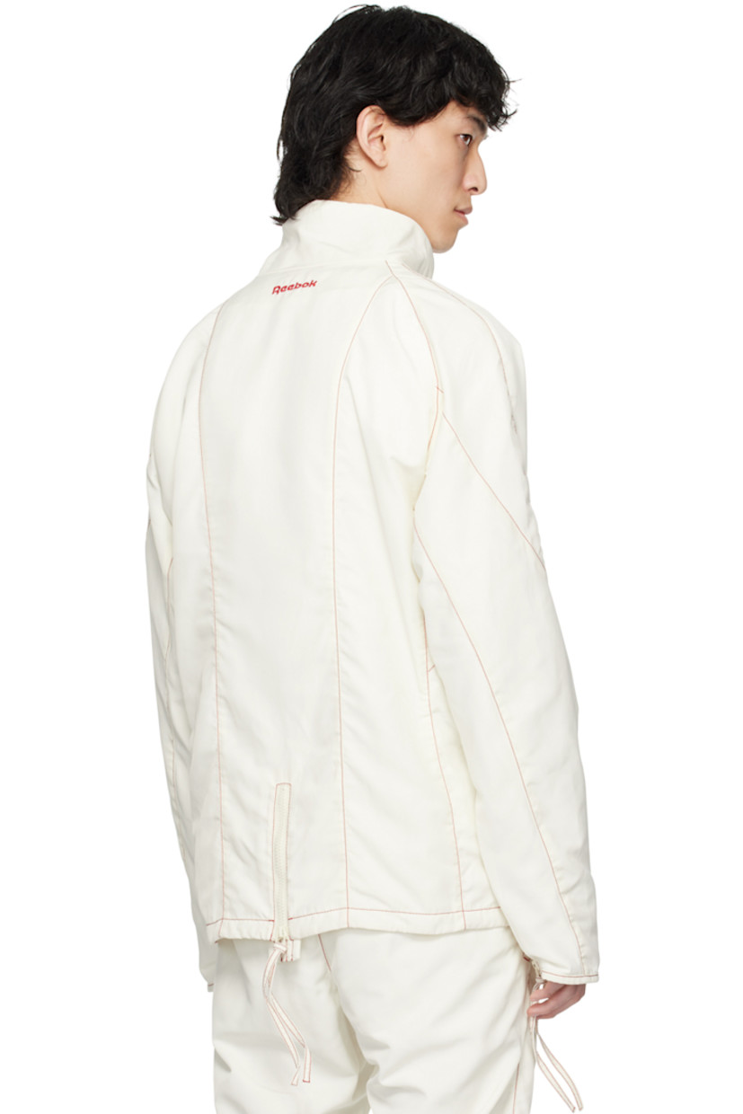 Polyester taffeta track jacket. 

· Paneled construction 
· Stand collar
· Zip closure
· Logo embroidered at chest and back collar
· Zip pockets
· Raglan sleeves
· Zip vent at cuffs and back hem
· Contrast stitching in red
· Full mesh lining 

Part of the Kanghyuk x Reebok collaboration. 

Supplier color: White/Red