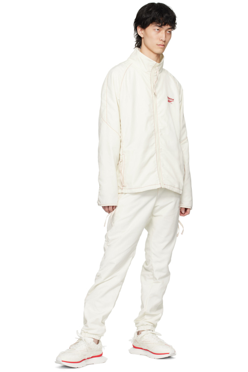 Polyester taffeta track jacket. 

· Paneled construction 
· Stand collar
· Zip closure
· Logo embroidered at chest and back collar
· Zip pockets
· Raglan sleeves
· Zip vent at cuffs and back hem
· Contrast stitching in red
· Full mesh lining 

Part of the Kanghyuk x Reebok collaboration. 

Supplier color: White/Red