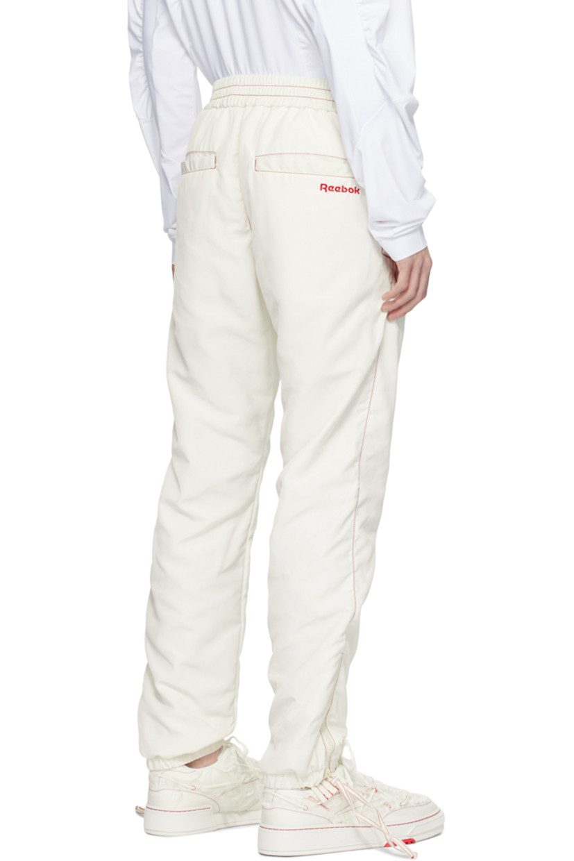 Polyester taffeta track pants. Zip vents throughout. 

· Paneled construction 
· Drawstring at elasticized waistband  
· Four-pocket styling 
· Logo embroidered at front and back 
· Elasticized cuffs 
· Full mesh lining 
· Contrast stitching in red 

Part of the Kanghyuk x Reebok collaboration. 

Supplier color: White/Red