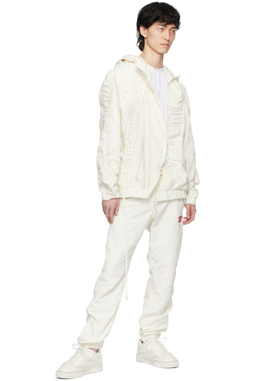 Polyester taffeta track pants. Zip vents throughout. 

· Paneled construction 
· Drawstring at elasticized waistband  
· Four-pocket styling 
· Logo embroidered at front and back 
· Elasticized cuffs 
· Full mesh lining 
· Contrast stitching in red 

Part of the Kanghyuk x Reebok collaboration. 

Supplier color: White/Red