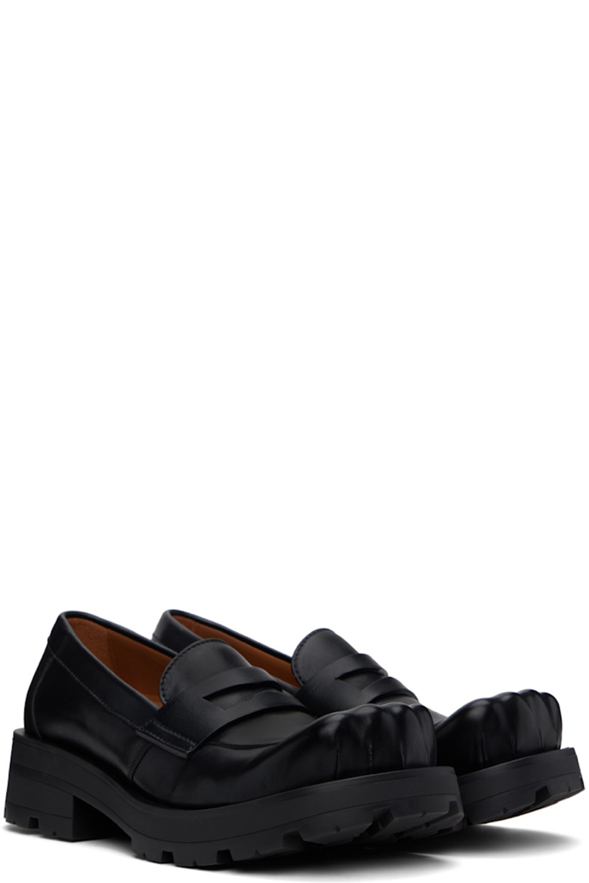 Buffed leather loafers in black.

· Sculptural square toe
· Strap with cutout at vamp
· Buffed leather lining
· Rubber block heel
· Stacked leather and foam rubber midsole
· Treaded rubber sole
· Heel: H1.75"

Supplier color: Black