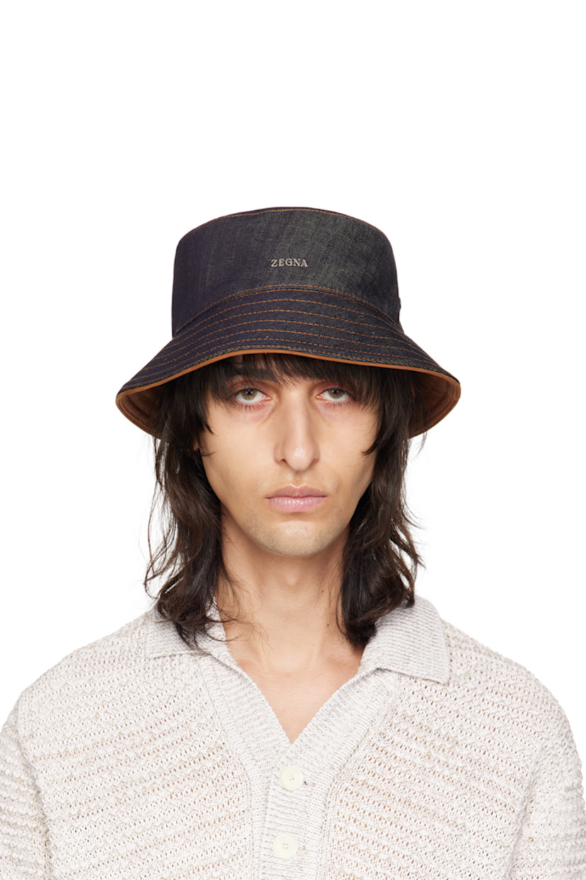 Non-stretch denim bucket hat in indigo.

· Quilted brim
· Logo hardware at side
· Logo flag at back face
· Grosgrain browband 
· Contrast stitching in orange

Supplier color: Blue