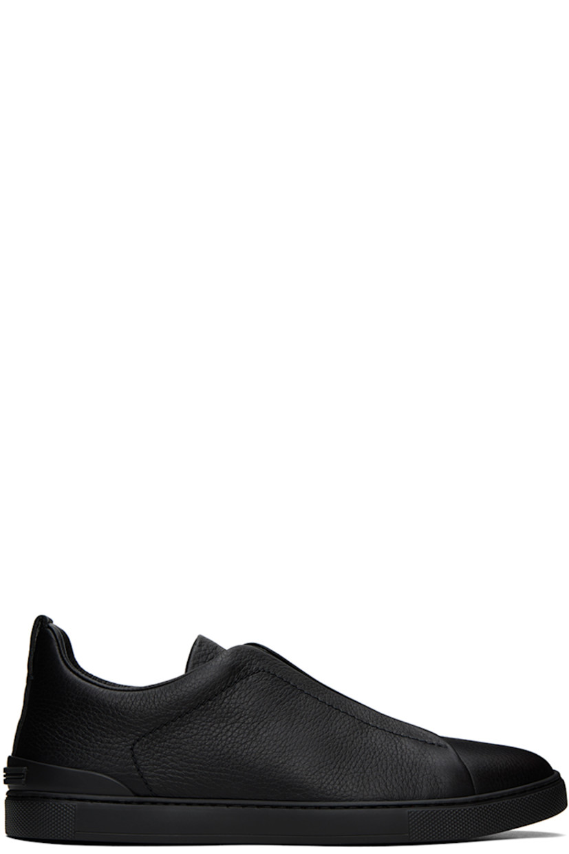 Low-top grained deerskin slip-on sneakers in black.

· Elasticized straps at vamp
· Logo embossed at padded tongue 
· Padded collar
· Pull-loop at heel collar
· Rubberized trim at heel
· Buffed leather lining
· Treaded rubber sole

Supplier color: Black
