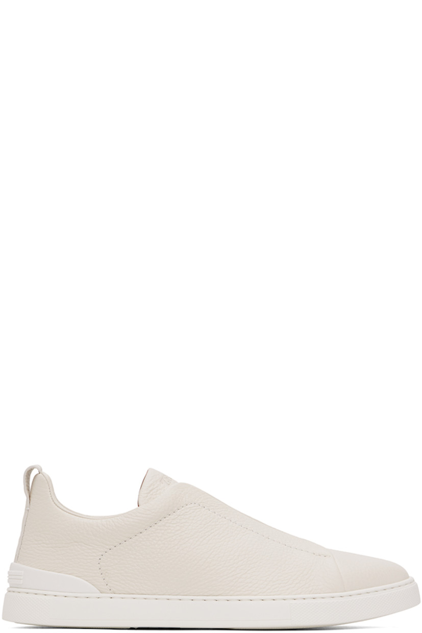 Low-top grained deerskin sneakers in off-white.

· Elasticized criss-crossing straps at vamp
· Logo embossed at padded tongue
· Concealed elasticized gussets at tongue
· Padded collar
· Pull-loop at heel tab
· Sanitized® footbed 
· Treaded rubber sole

Supplier color: Off-White