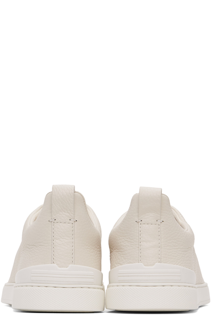 Low-top grained deerskin sneakers in off-white.

· Elasticized criss-crossing straps at vamp
· Logo embossed at padded tongue
· Concealed elasticized gussets at tongue
· Padded collar
· Pull-loop at heel tab
· Sanitized® footbed 
· Treaded rubber sole

Supplier color: Off-White