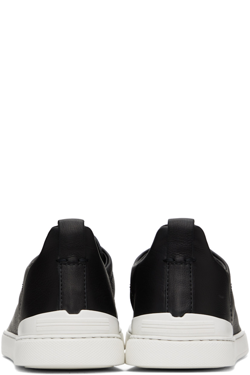 Low-top grained leather slip-on sneakers in black.

· Elasticized criss-crossing straps at vamp
· Logo embossed at padded tongue
· Padded collar
· Pull-loop at heel collar
· Rubberized logo patch at heel counter
· Cushioned Sanitized® insole
· Buffed leather lining
· Treaded rubber sole

Supplier color: Nero