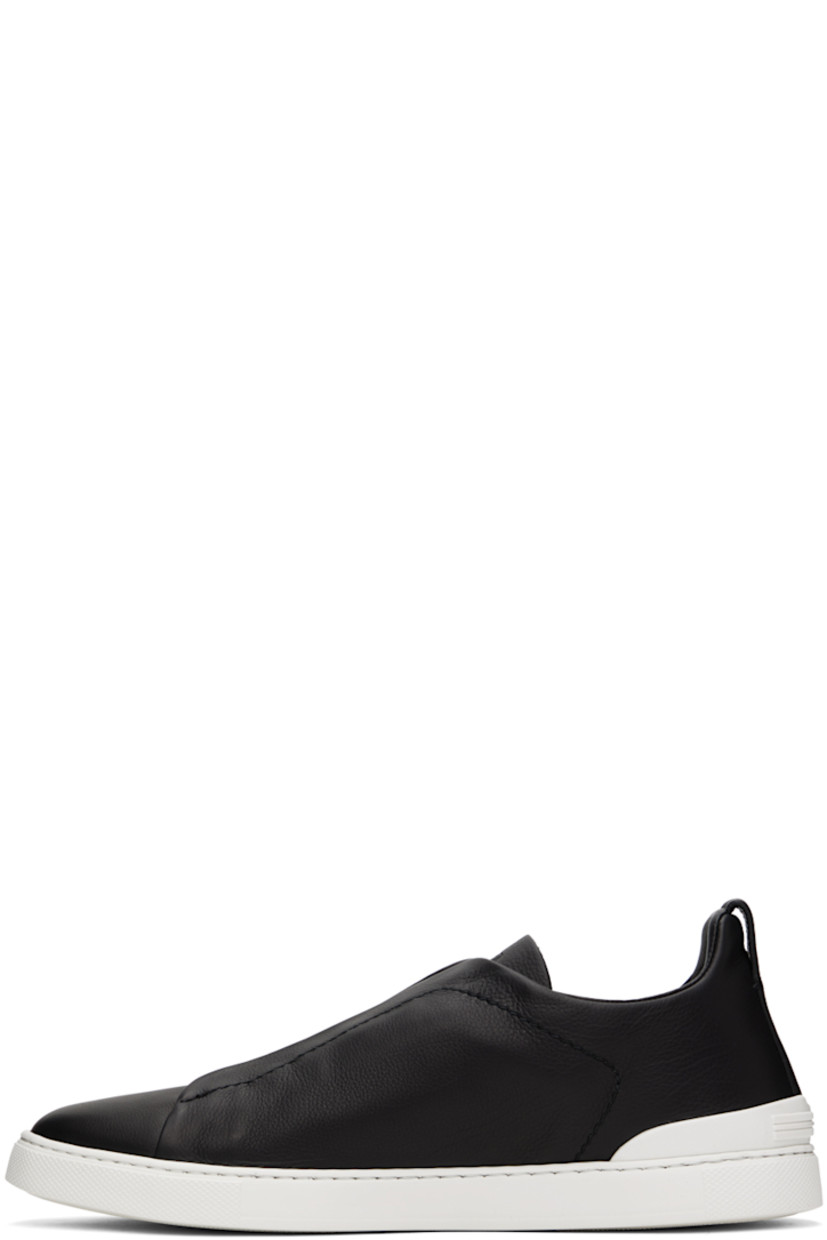 Low-top grained leather slip-on sneakers in black.

· Elasticized criss-crossing straps at vamp
· Logo embossed at padded tongue
· Padded collar
· Pull-loop at heel collar
· Rubberized logo patch at heel counter
· Cushioned Sanitized® insole
· Buffed leather lining
· Treaded rubber sole

Supplier color: Nero