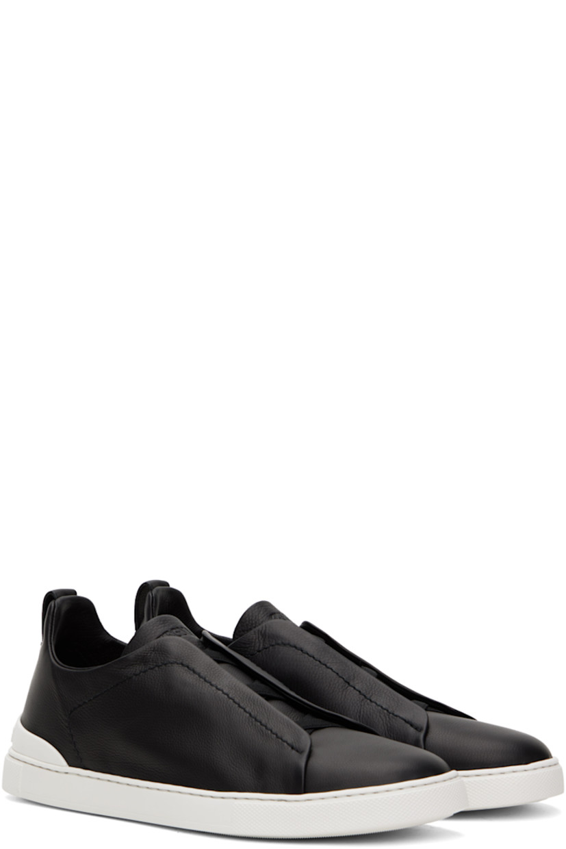 Low-top grained leather slip-on sneakers in black.

· Elasticized criss-crossing straps at vamp
· Logo embossed at padded tongue
· Padded collar
· Pull-loop at heel collar
· Rubberized logo patch at heel counter
· Cushioned Sanitized® insole
· Buffed leather lining
· Treaded rubber sole

Supplier color: Nero