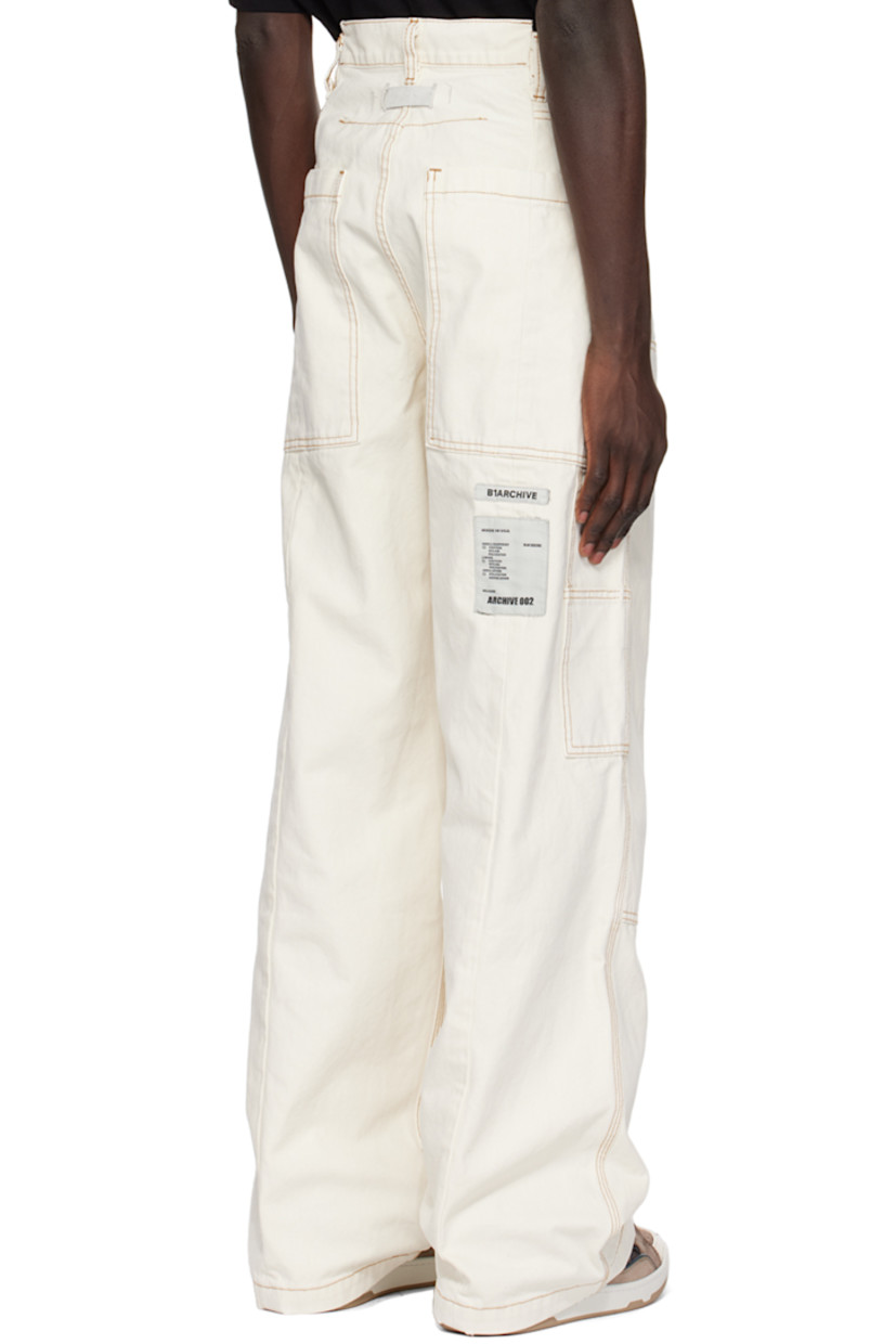 Wide-leg stone-washed cotton canvas trousers.

· Belt loops
· Five-pocket styling
· Button-fly
· Panels at front legs 
· Patch pockets and hammer loop at outseams
· Offset detailing at back waistband
· Locker loop at back 
· Logo patches at back leg
· Central seam at back legs
· Contrast stitching in brown

Supplier color: Ecru