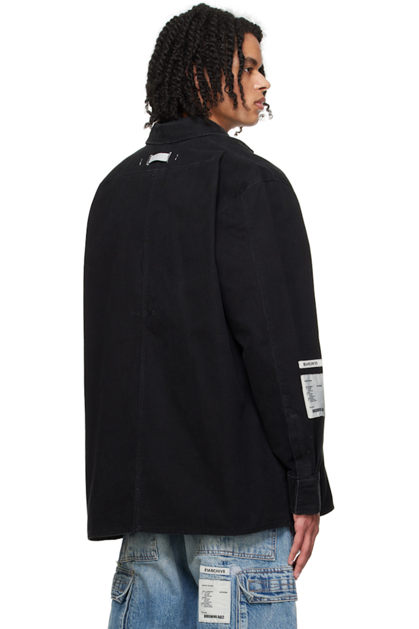 Cotton canvas shirt. Subtle fading throughout. 

· Spread collar
· Concealed button closure
· Patch pocket 
· Logo embroidered at hem 
· Logo patches at sleeve
· Single-button barrel cuffs 
· Locker loop at back collar
· Central seam and logo embroidered at back

Supplier color: Canvas black