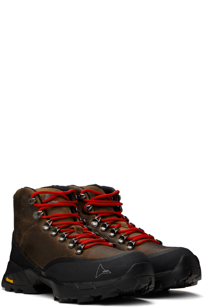 Ankle-high LWG-certified waxed kudu leather boots in brown.

· Rubberized trim throughout
· Logo printed at rubber cap toe
· Lace-up closure
· Logo embroidered at padded tongue
· Padded collar
· Logo embroidered at inner side
· Pull-loop at heel collar
· Jersey lining
· Treaded Vibram® Megagrip rubber sole

Supplier color: Noix