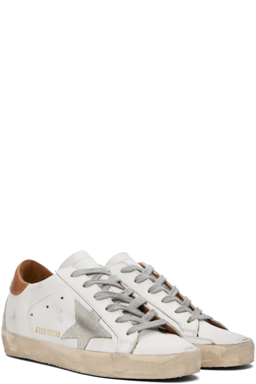 Handcrafted low-top buffed leather sneakers in white and brown. 

· Smudging throughout
· Lace-up closure
· Perforated detailing at tongue and sides
· Padded collar
· Signature star appliqué and text printed at outer side
· Logo embossed at heel tab
· Suede and terrycloth lining
· Treaded rubber sole

Available exclusively at SSENSE.

Supplier color: White/Brown