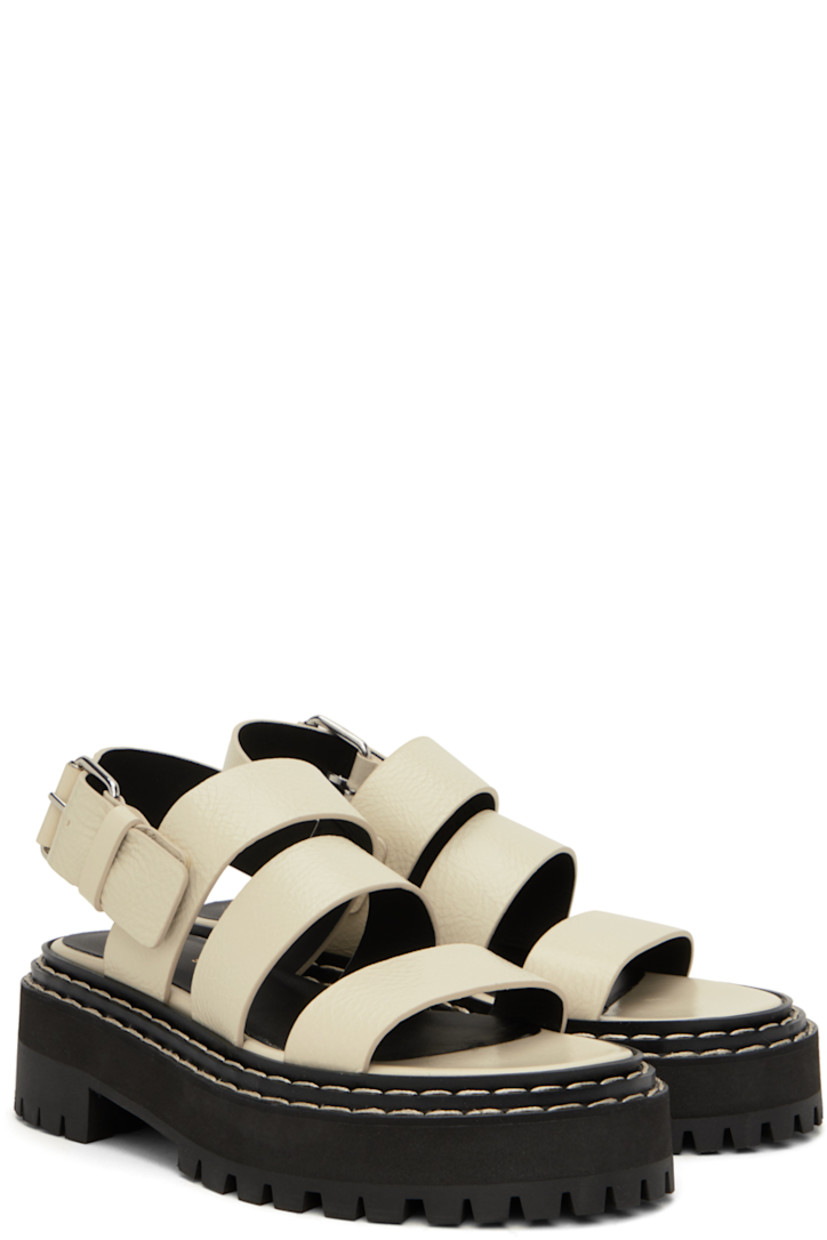 Grained calfskin sandals in off-white. 

· Straps at vamp
· Pin-buckle ankle strap
· Logo printed at leather footbed
· Topstitching at tiered welt
· Foam rubber platform midsole
· Lug rubber sole
· Platform: H1.25"
· Heel: H1.75"

Supplier color: Natural