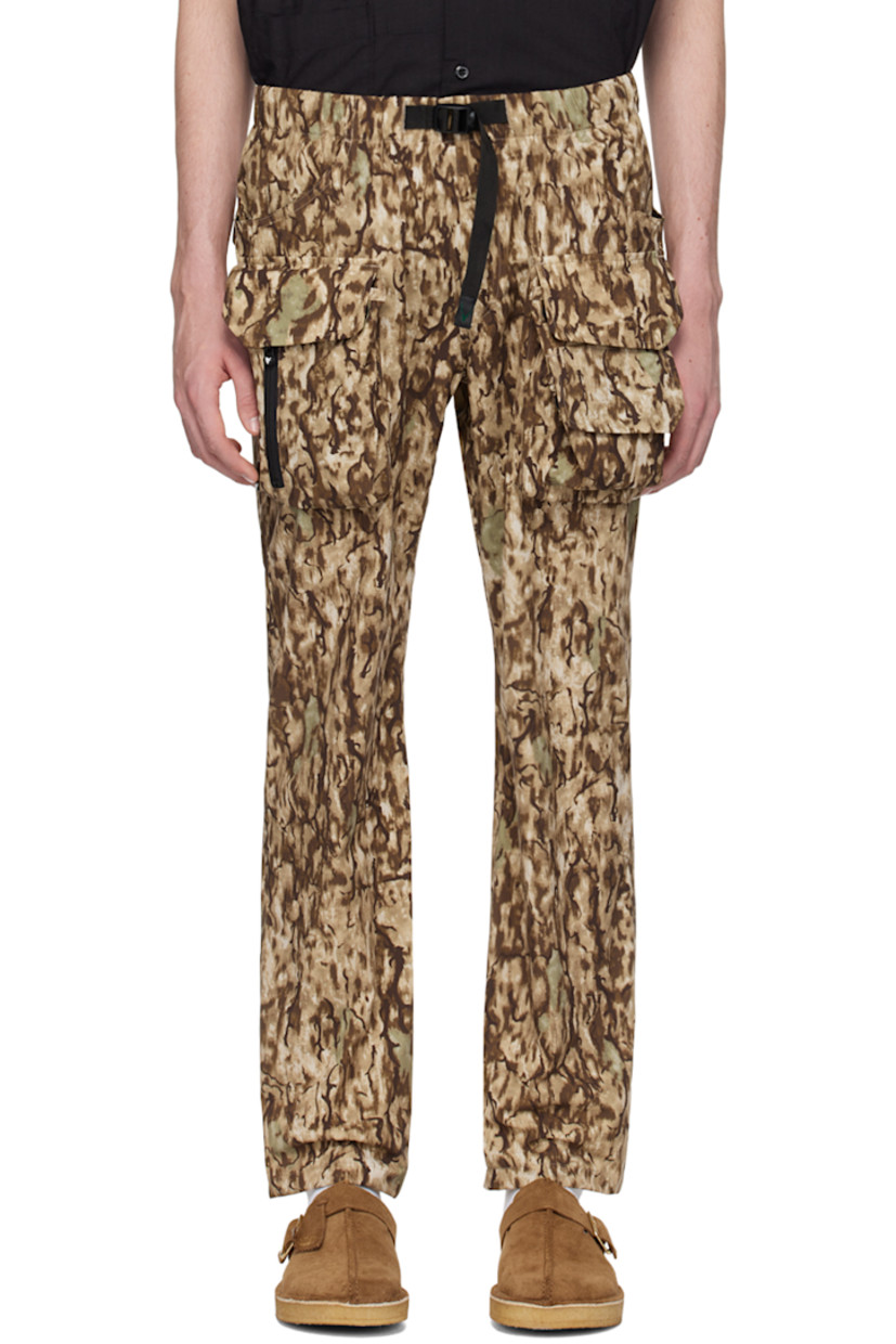 Polyester ripstop trousers. Camouflage pattern printed throughout. 

· Paneled construction
· Integrated webbing cinch belt at waist
· Elasticized waistband 
· Four-pocket styling
· D-ring and bellows pockets at front
· Zip pockets at front
· Logo patch at back pocket

Supplier color: Horn camo