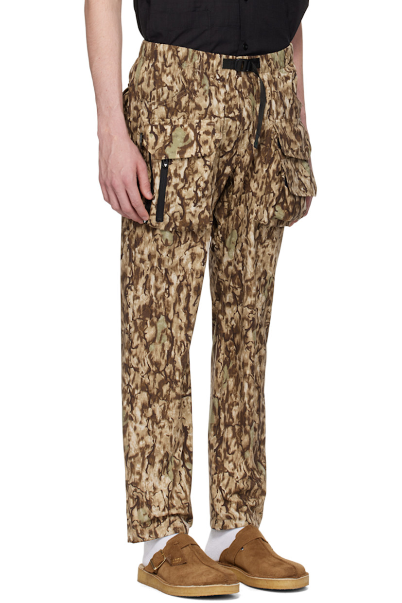 Polyester ripstop trousers. Camouflage pattern printed throughout. 

· Paneled construction
· Integrated webbing cinch belt at waist
· Elasticized waistband 
· Four-pocket styling
· D-ring and bellows pockets at front
· Zip pockets at front
· Logo patch at back pocket

Supplier color: Horn camo