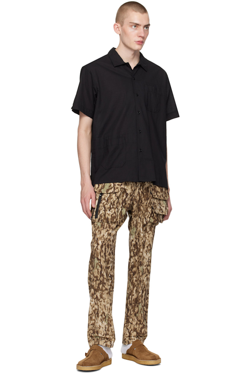 Polyester ripstop trousers. Camouflage pattern printed throughout. 

· Paneled construction
· Integrated webbing cinch belt at waist
· Elasticized waistband 
· Four-pocket styling
· D-ring and bellows pockets at front
· Zip pockets at front
· Logo patch at back pocket

Supplier color: Horn camo