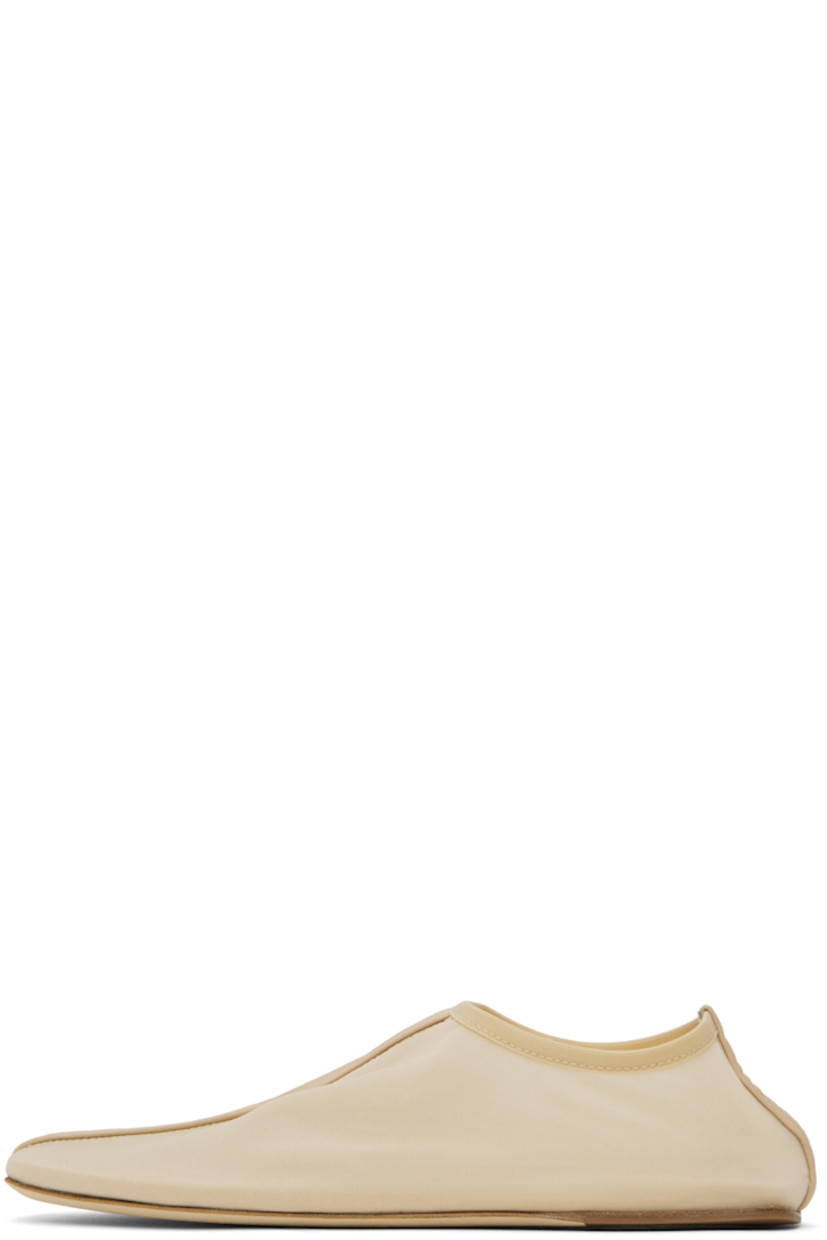 Semi-sheer nylon mesh slippers in beige.

· Central seam at vamp and heel counter
· Elasticized collar
· Logo embossed at padded footbed
· Nubuck and rubber sole

Supplier color: Butter