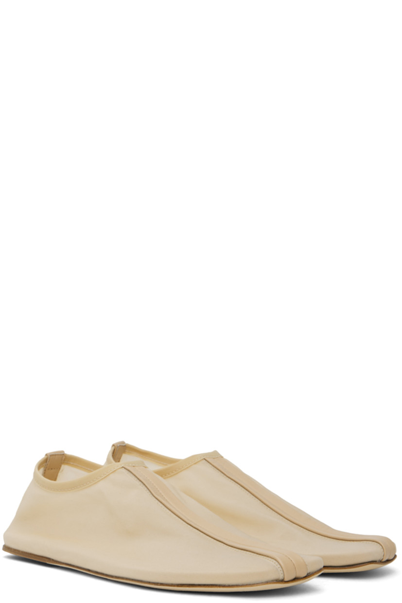 Semi-sheer nylon mesh slippers in beige.

· Central seam at vamp and heel counter
· Elasticized collar
· Logo embossed at padded footbed
· Nubuck and rubber sole

Supplier color: Butter