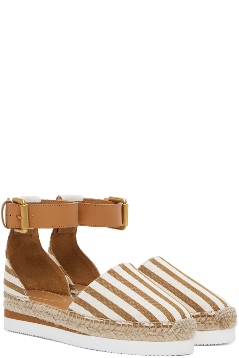 Canvas espadrilles in brown and off-white.

· Stripes throughout
· Buffed leather pin-buckle ankle strap
· Logo embossed at padded calfskin footbed
· Suede and buffed calfskin lining
· Blanket stitching at welt
· Braided jute midsole
· Treaded foam rubber platform sole
· Platform: H1.5"

Supplier color: Tan