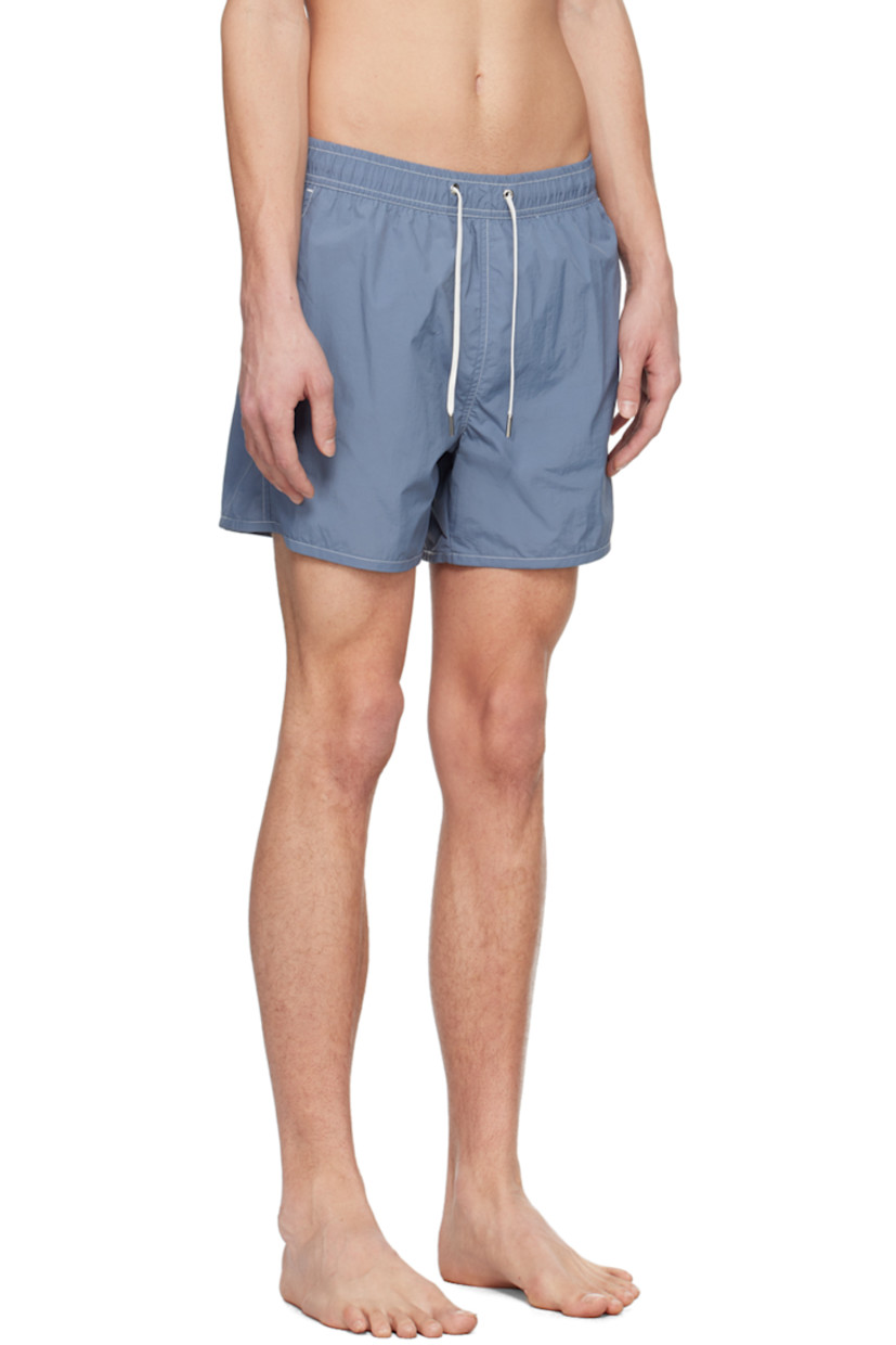 Quick-drying crinkled recycled nylon taffeta swim shorts.

· Drawstring at elasticized waistband
· Three-pocket styling
· Metal eyelets at back
· Partial mesh lining
· Contrast stitching in white

Supplier color: Juniper