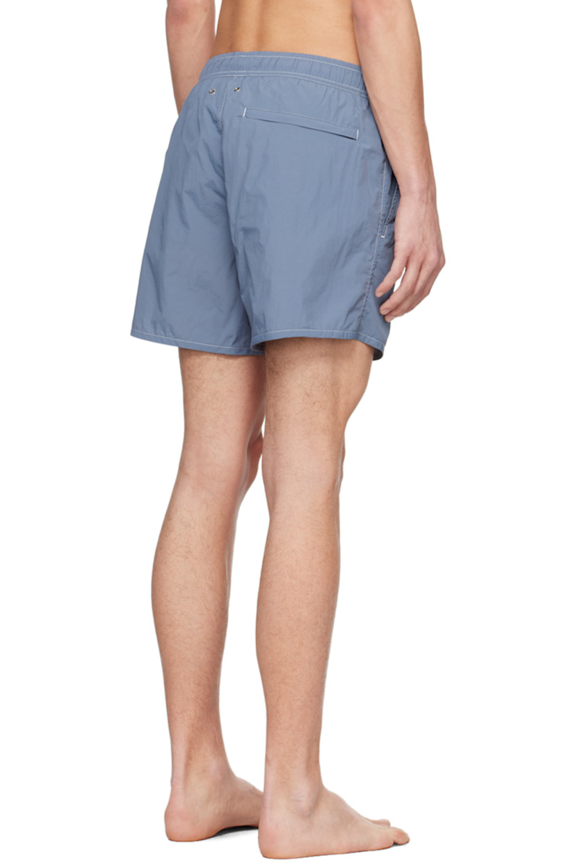 Quick-drying crinkled recycled nylon taffeta swim shorts.

· Drawstring at elasticized waistband
· Three-pocket styling
· Metal eyelets at back
· Partial mesh lining
· Contrast stitching in white

Supplier color: Juniper