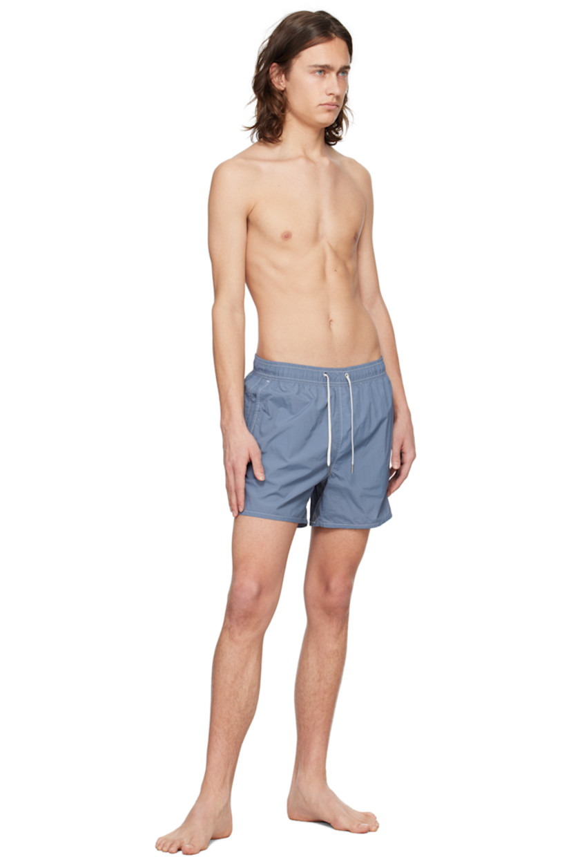 Quick-drying crinkled recycled nylon taffeta swim shorts.

· Drawstring at elasticized waistband
· Three-pocket styling
· Metal eyelets at back
· Partial mesh lining
· Contrast stitching in white

Supplier color: Juniper