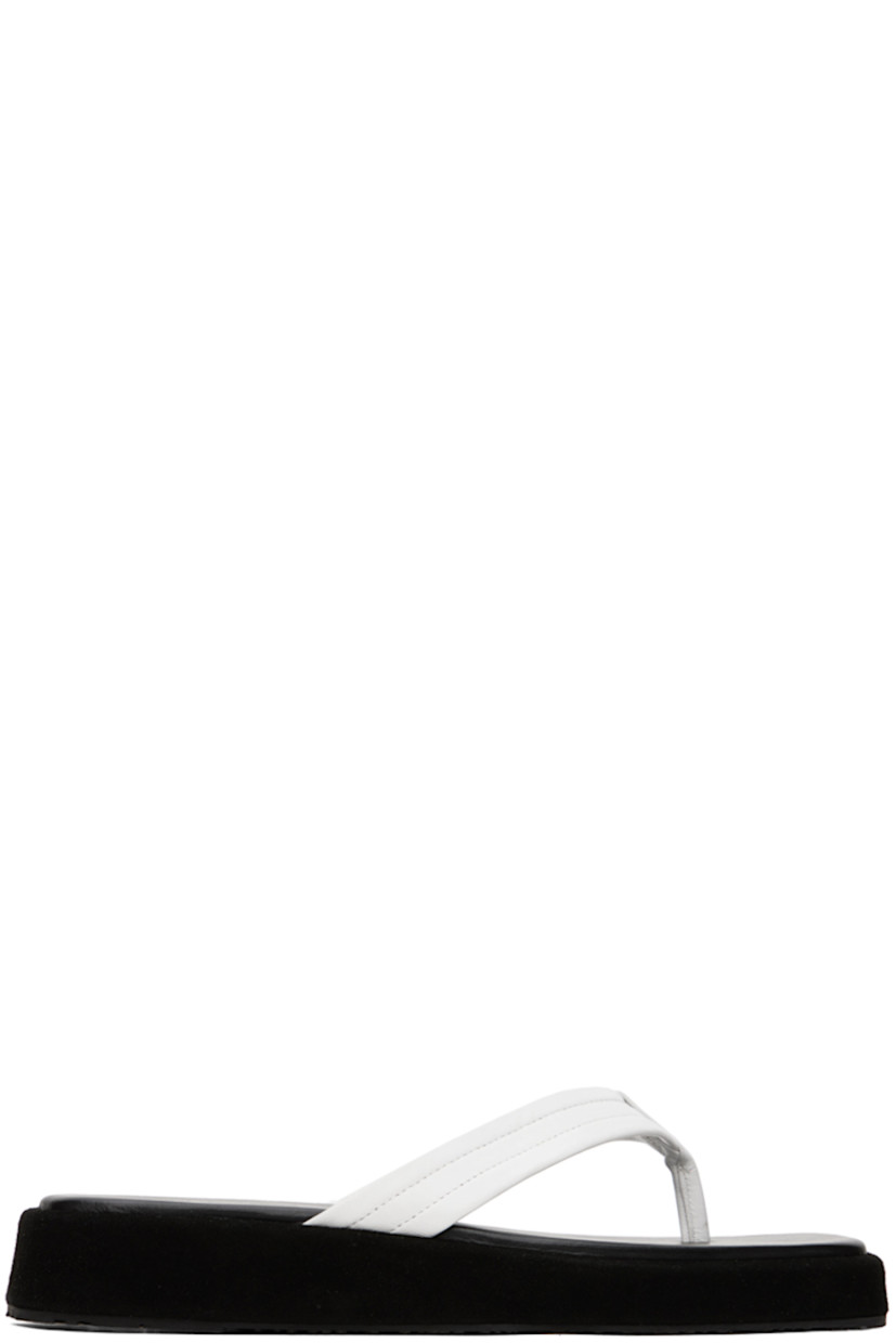Buffed leather and suede flip flops in black and white.

· Open square toe
· Thong-style strap at vamp
· Logo embossed at padded leather footbed
· Suede-covered foam rubber midsole
· Treaded rubber sole

Supplier color: White