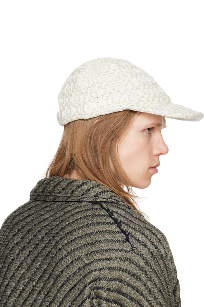 Handcrafted knit cotton cap in off-white.

· Jacquard check pattern throughout
· Flat brim
· Elasticized trim at back face
· Unlined

Supplier color: Chalk