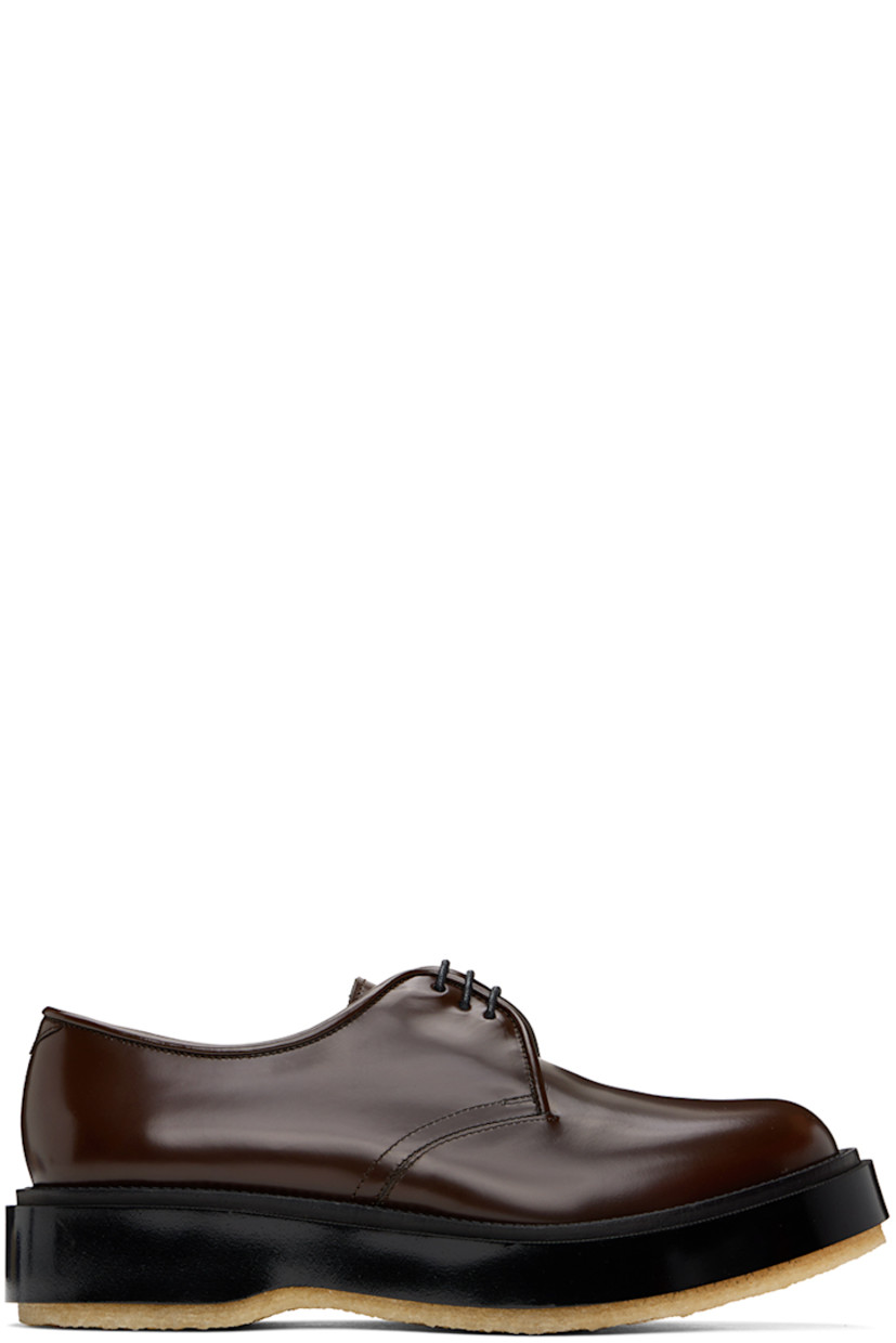 Polished calfskin derbys in brown.

· Lace-up closure
· Suede lining in black 
· Textured rubber midsole
· Crepe rubber sole
· Heel: H1.25"

Supplier color: Dark brown espresso