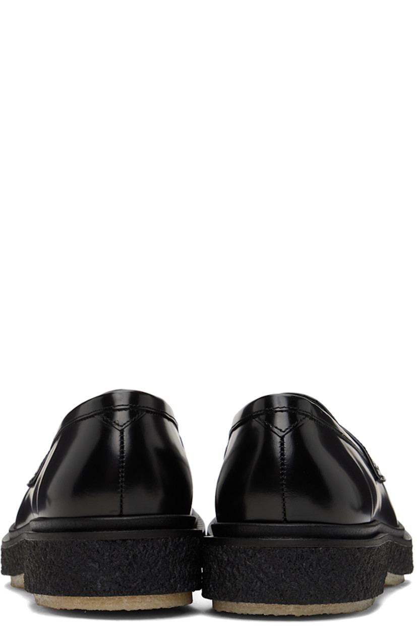 Polished leather loafers in black.

· Moc toe
· Strap with cutout at vamp
· Logo printed at padded leather footbed
· Suede and buffed leather lining 
· Scalloped detailing at welt
· Crepe rubber sole
· Heel: H1.25"

Supplier color: Black