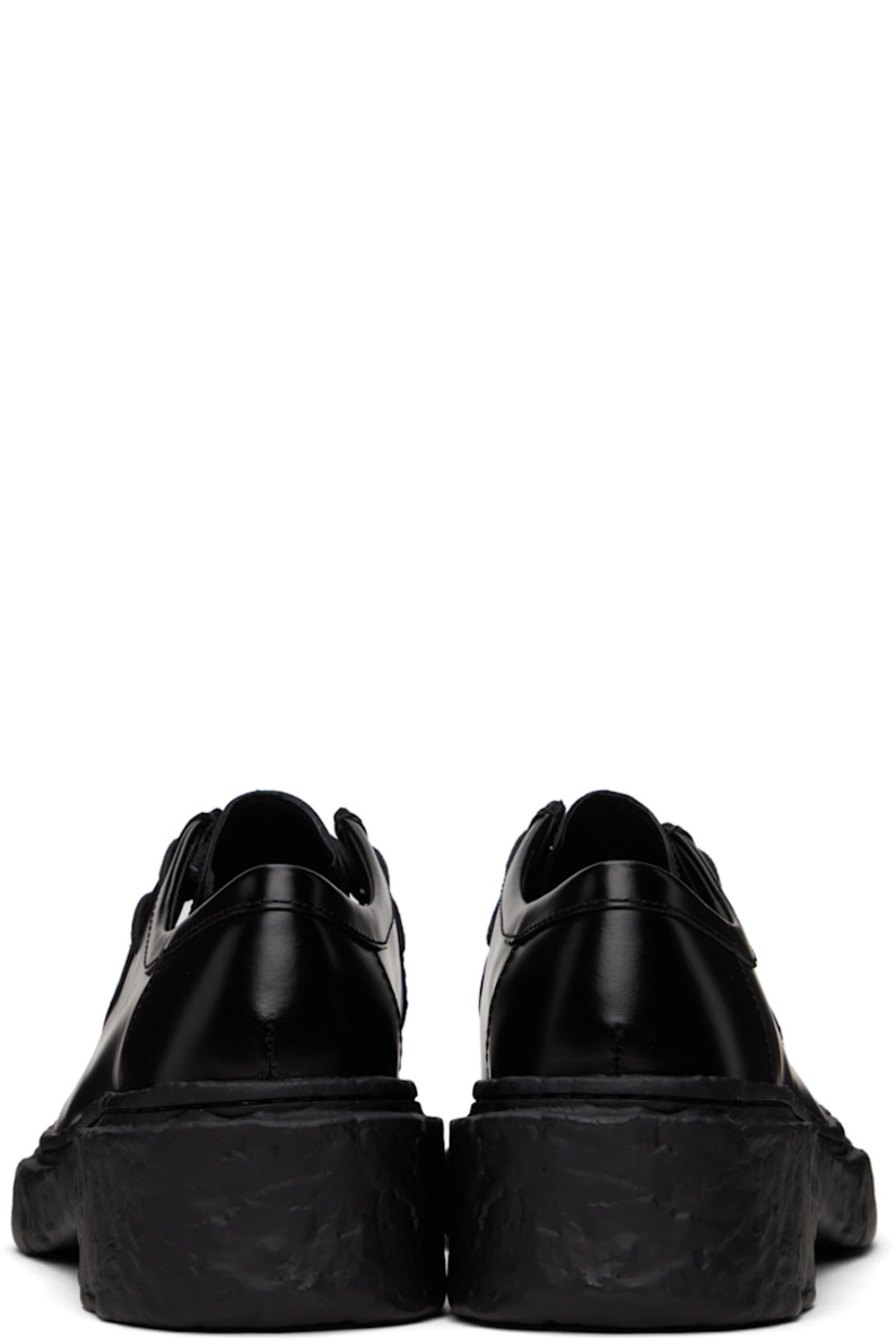 Polished calfskin derbys in black.

· Moc toe
· Lace-up closure
· Cushioned OrthoLite® Recycled™ footbed
· Suede and buffed leather lining
· Sculptural treaded PU sole

Supplier color: Black