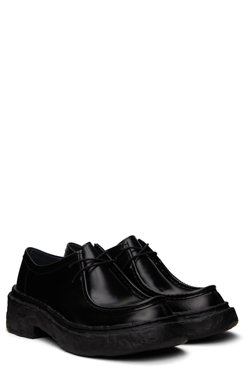 Polished calfskin derbys in black.

· Moc toe
· Lace-up closure
· Cushioned OrthoLite® Recycled™ footbed
· Suede and buffed leather lining
· Sculptural treaded PU sole

Supplier color: Black
