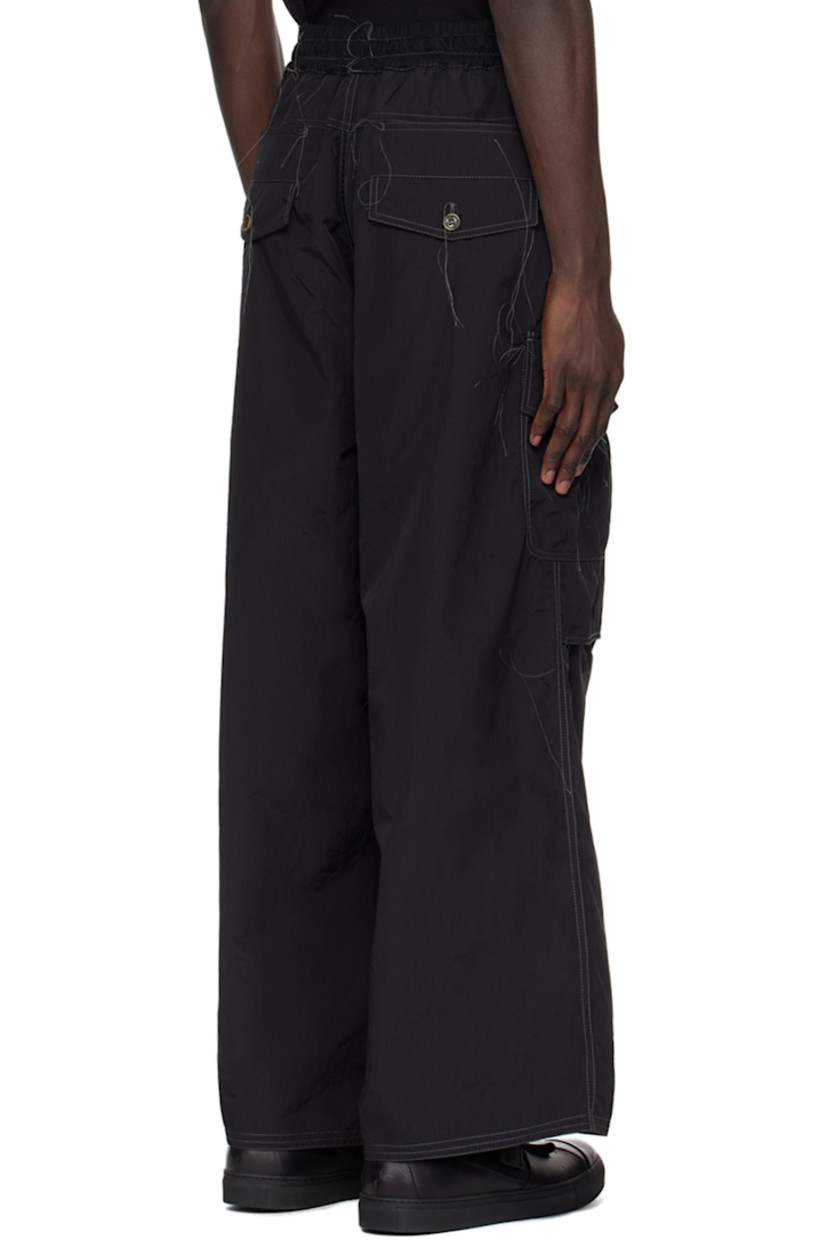 Handcrafted stretch nylon faille trousers. Loose thread detailing throughout. 

· Drawstring at elasticized waistband
· Four-pocket styling
· Zip-fly
· Darts and tucks at knees
· Partial cotton twill lining
· Contrast stitching in gray

Supplier color: Black